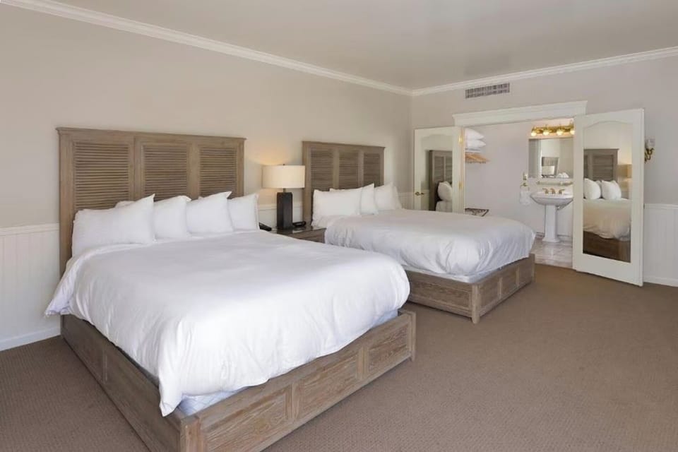 Sink into plush beds in a calm, sunlit sanctuary.