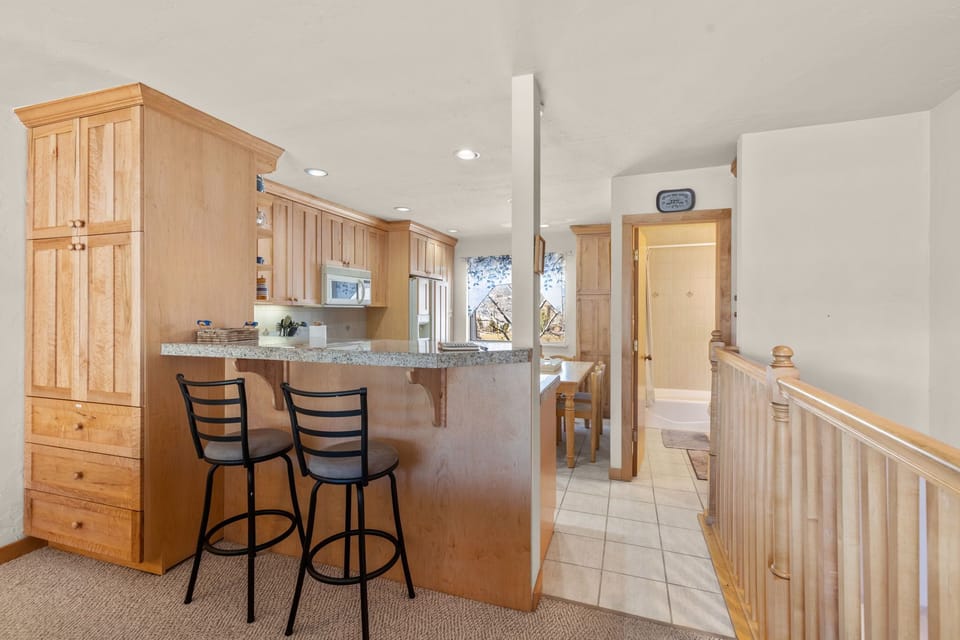 Breakfast bar between kitchen and living area with seating for 2.
