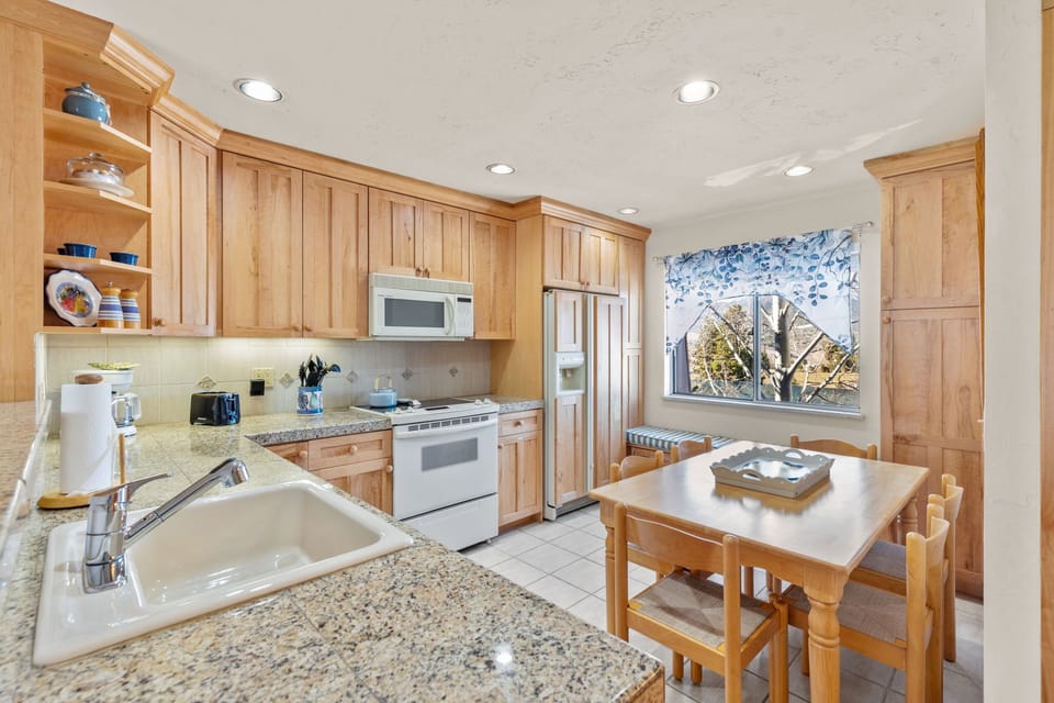 Dining room table with seating for 6 people with daybed underneath window.