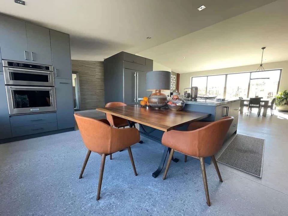 Estate 1 - Fully equipped luxury kitchen stocked with all culinary essentials and features high-end stainless-steel appliances, a kitchen island, a breakfast table, and a wet bar/coffee station.