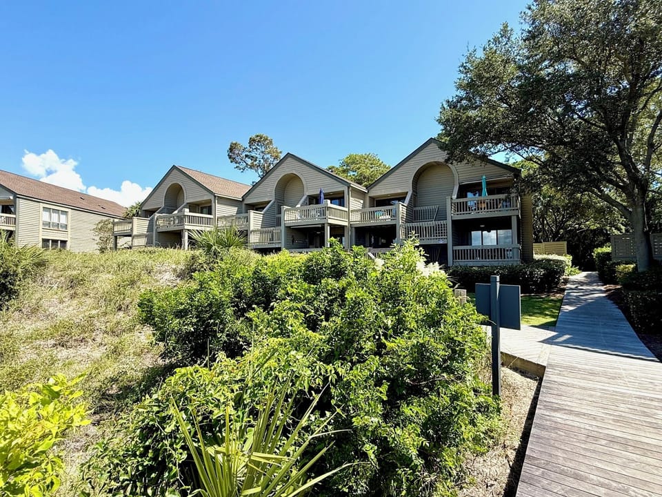 Welcome to the quiet villa complex, surrounded by lush landscaping and featuring private balconies for enjoying the coastal setting.