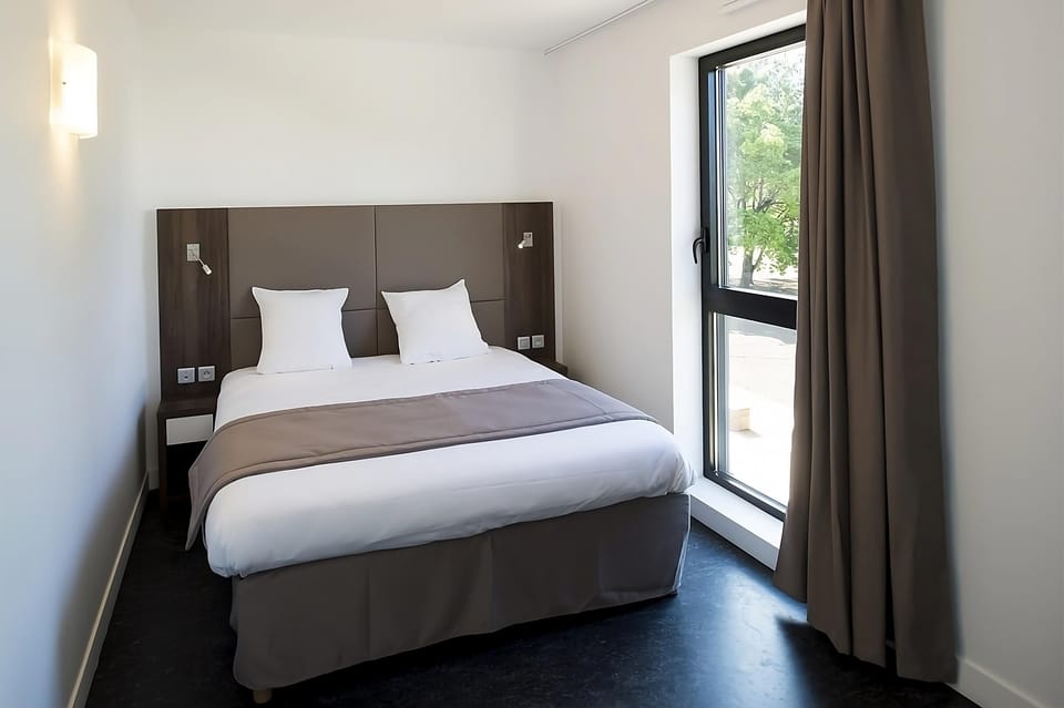 Wake up refreshed beside tall windows and calming neutral tones.