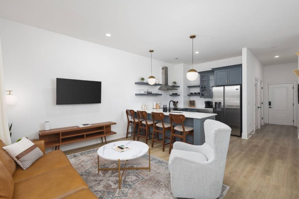 Condo 1 - Lots of natural light in the living room with a Smart TV & all the streaming apps. Open floor plan flows into the kitchen area.