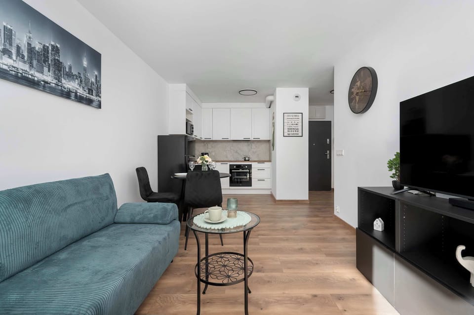 A compact kitchen with white cabinets, oven, and gray backsplash. Functional design for everyday cooking.