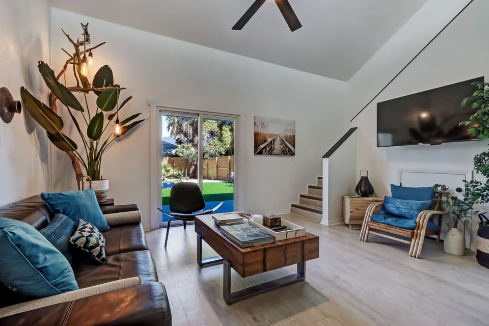 Bright boho living room with vaulted ceilings and backyard access.