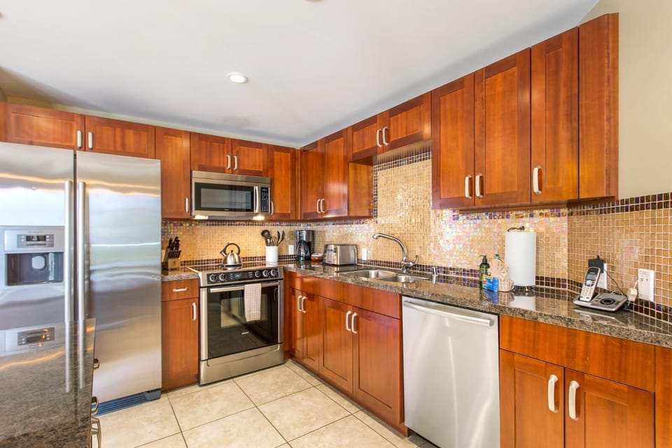HKH-323 Fully equipped kitchen with sleek finishes, breakfast bar, and open flow into living and dining spaces