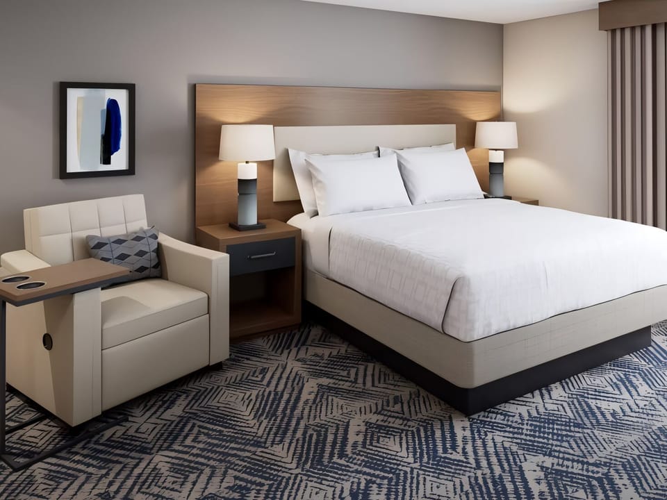 Unwind beneath warm bedside lamps in a serene queen bed.