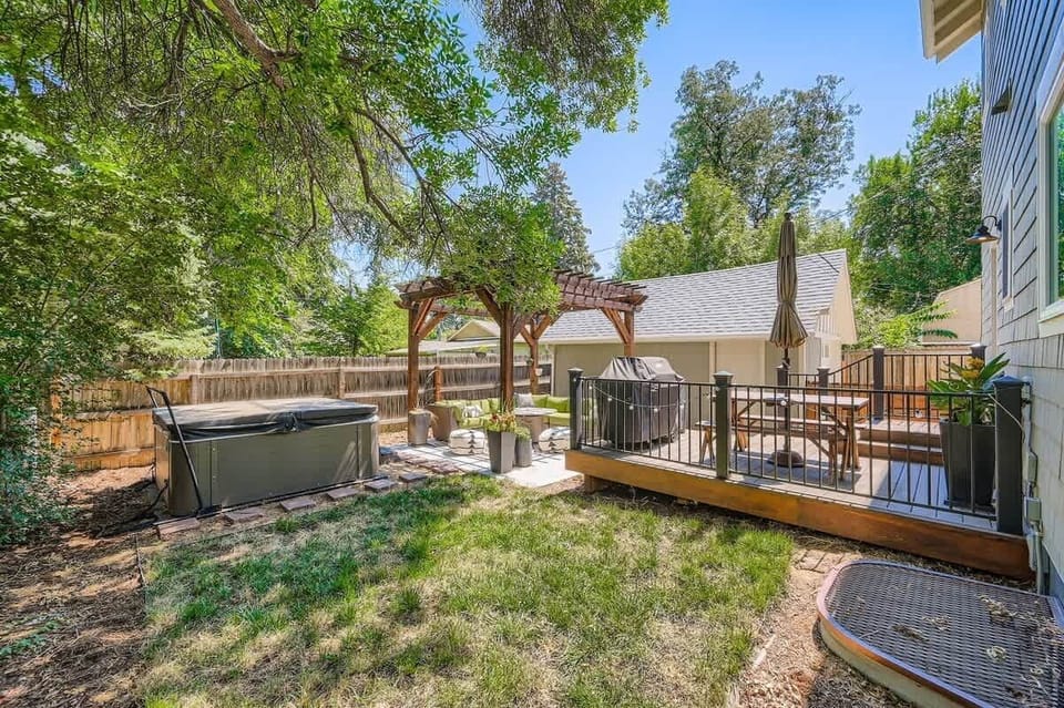 Private backyard featuring a hot tub and ample seating, perfect for relaxation and entertaining