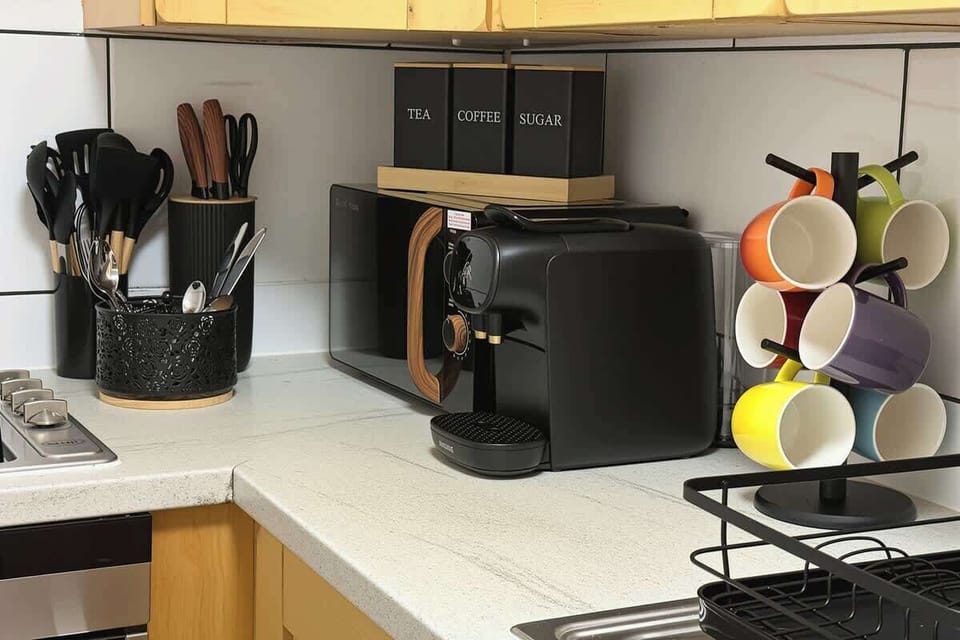Modern kitchen with oven, microwave, coffee machine and essentials for everyday cooking