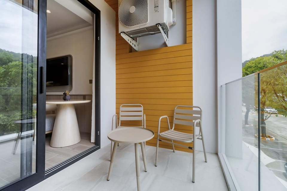 Balcony seating area with outdoor chairs and fresh natural view.
