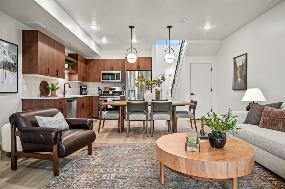 The living room flows seamlessly into the kitchen and dining areas, designed for gathering and connection.