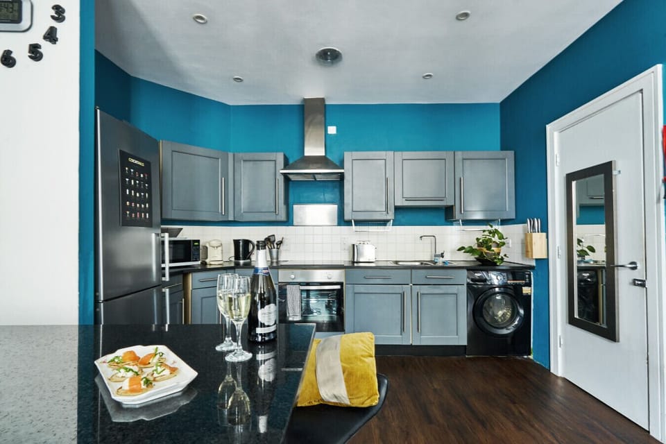 Open Plan Kitchen: Bright blues and sleek appliances make cooking a delight! Cheers to a tasty getaway!