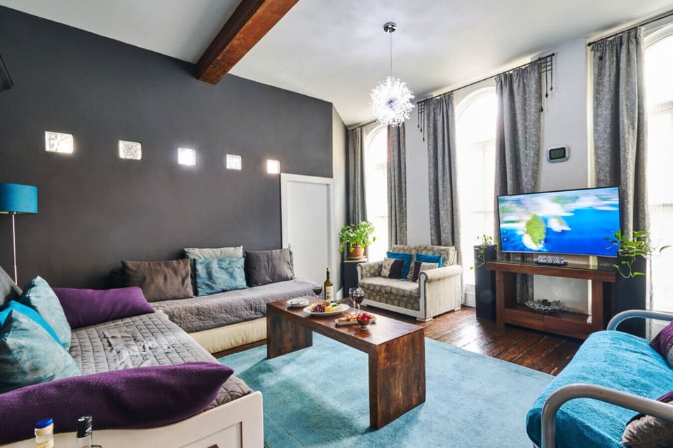 Living Room: Bright and airy space with stylish decor, plush seating, and vibrant touches for relaxation. Floor to ceiling windows and a large flat screen TV!