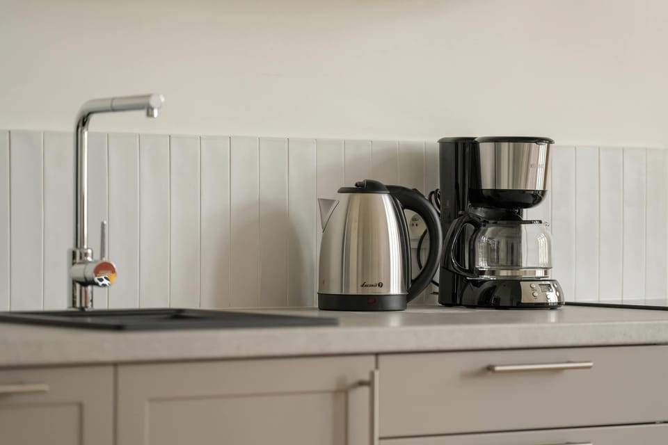 The kitchen counter with a coffee maker and kettle provides convenience for preparing aromatic coffee or tea at any time.