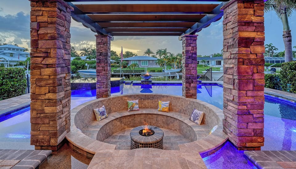 Waterfront fire pit with curved seating and canal view
