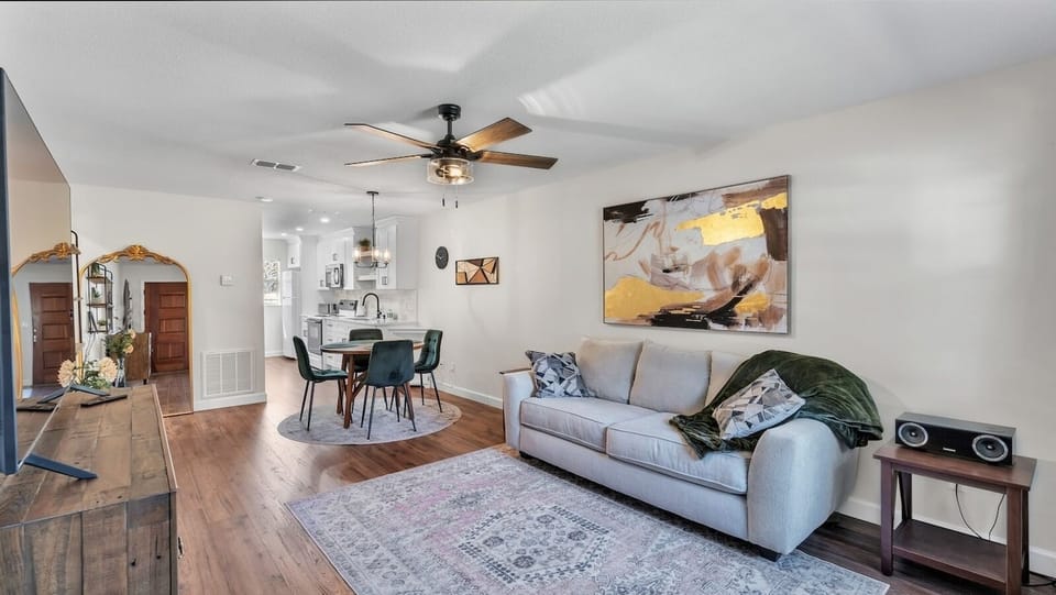 Cozy, modern living and dining room combo with sleek furniture and warm tones. Features a large TV, comfy seating, and a stylish dining area. Perfect for relaxing or gathering, this open layout blends comfort and function seamlessly.