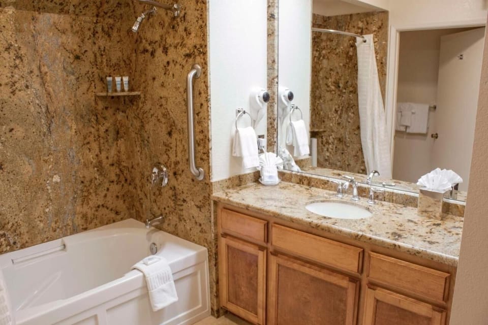 Refresh in a spacious bath with granite vanity and tub.