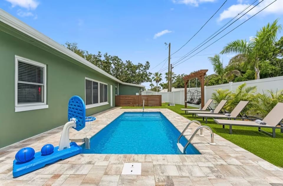 Magnificent backyard with pool, swings, lounge chairs, fire pit, cornhole, bowli