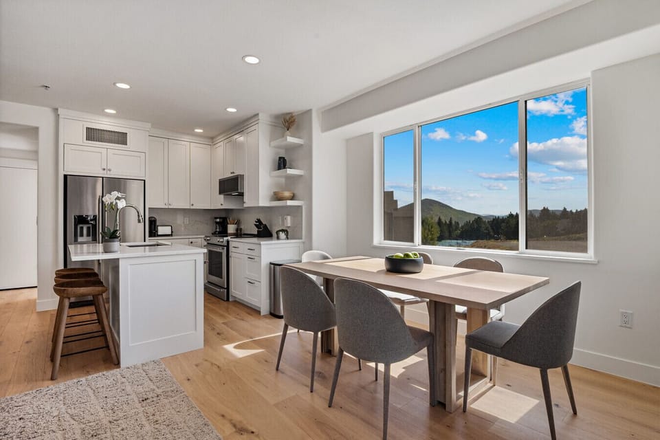 Bright and open dining area with seating for 6 adjacent to kitchen with breakfast bar