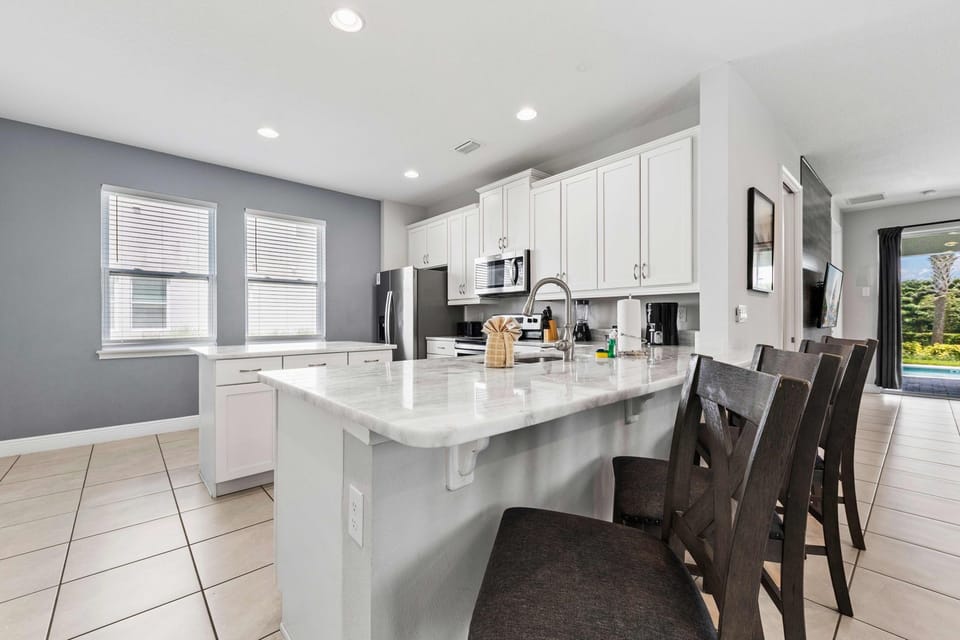 Modern kitchen with marble countertops and a view of the pool, perfect for entertaining.