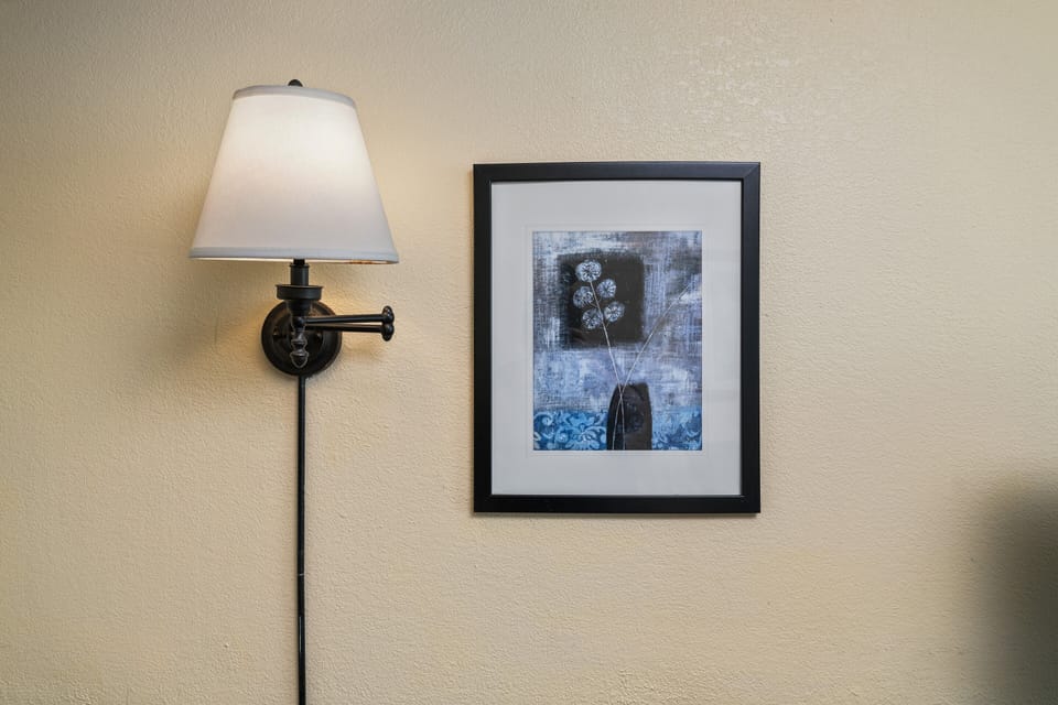 Classic wall sconce beside monochrome beach photography