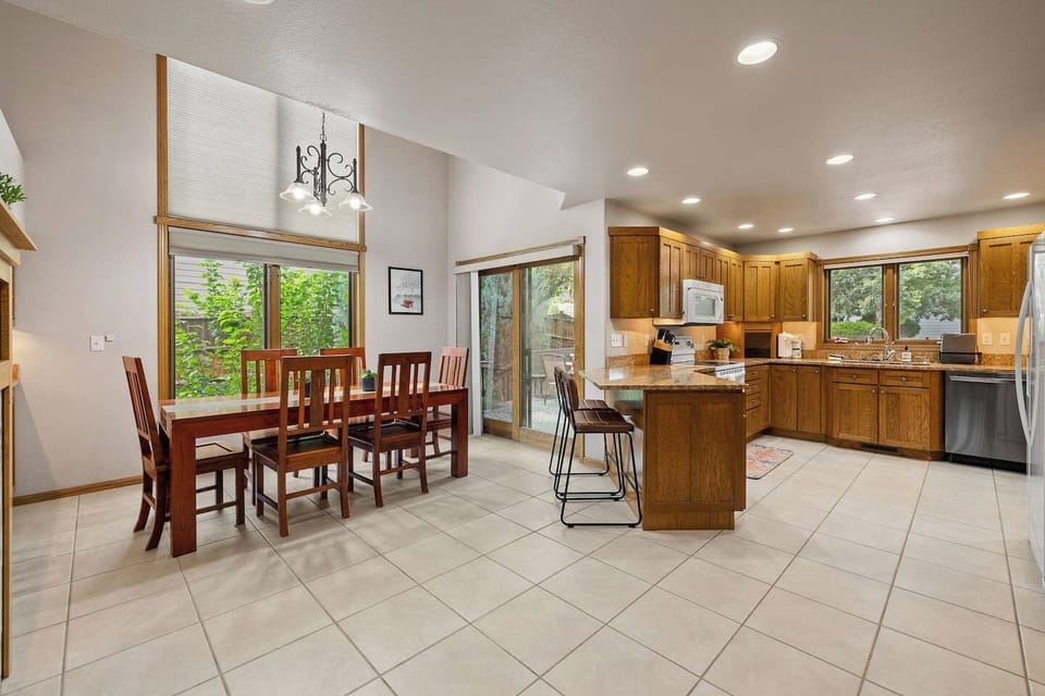 A modern kitchen seamlessly flows into a cozy dining area with a stylish table perfect for family meals.