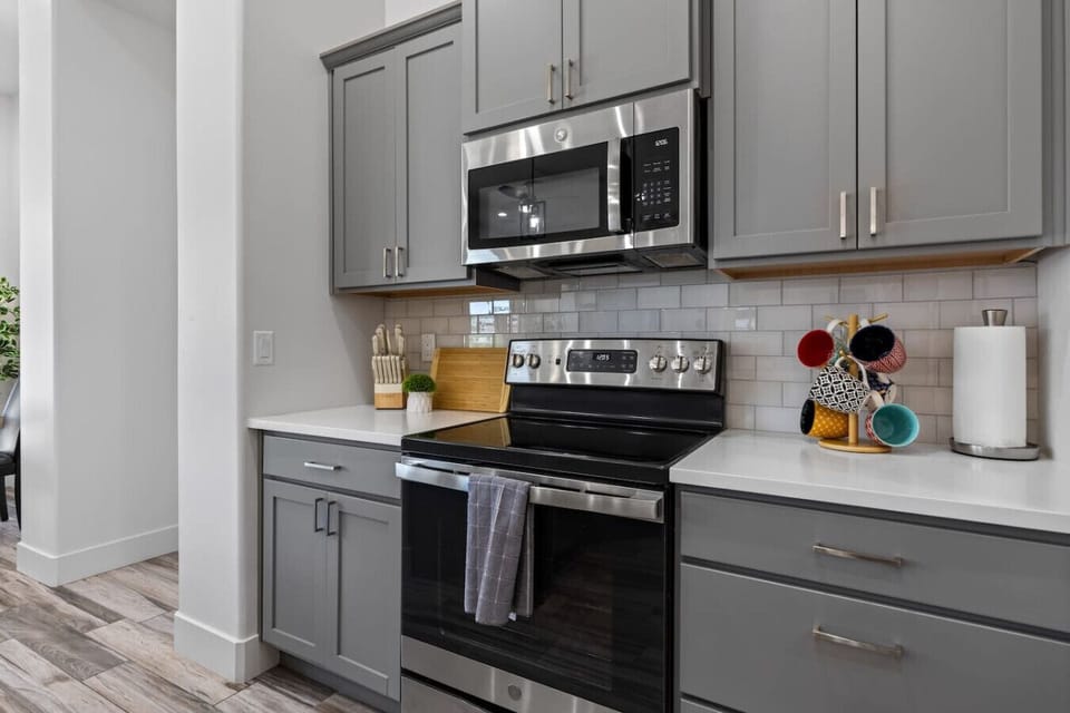 Fully stocked kitchen with Keurig coffee, olive oil, spices, and condiments.