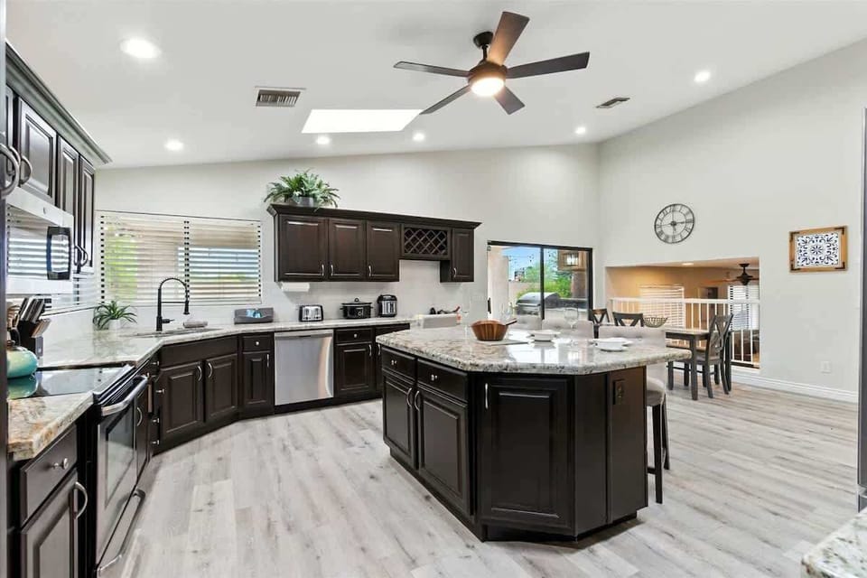 The kitchen features granite countertops, stainless steel appliances, and a spacious island with seating for family and friends.