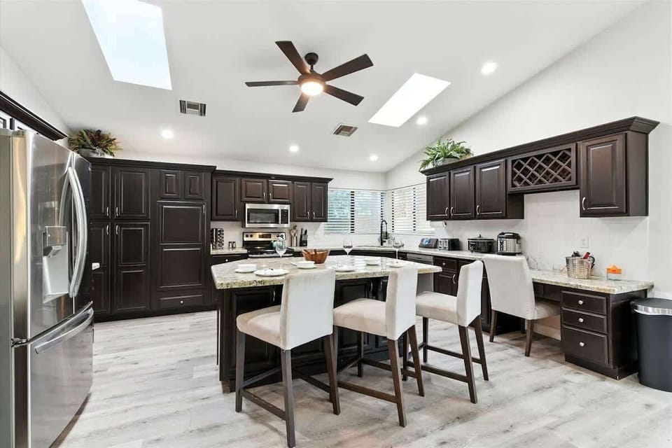 The kitchen features granite countertops, stainless steel appliances, and a spacious island with seating for family and friends.