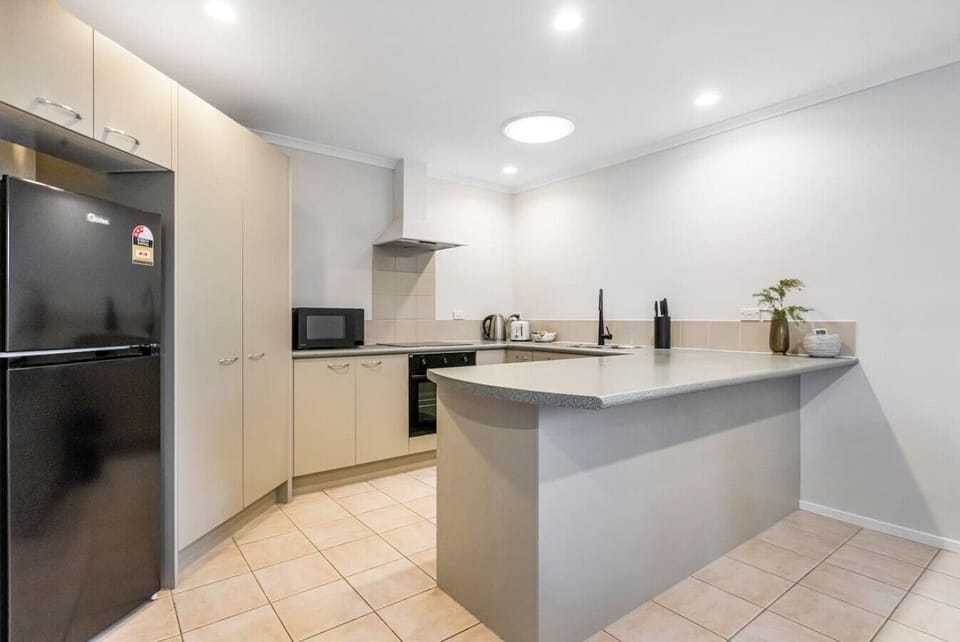 The kitchen has a cooktop, oven, dishwasher, microwave and fridge/freezer.
