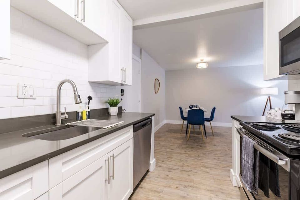 A refined kitchen flows seamlessly into a stylish dining space, where modern design meets understated elegance
