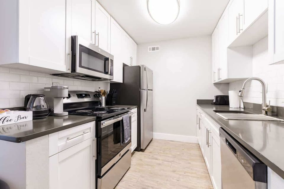 A sleek kitchen with stainless steel appliances and pristine white cabinetry