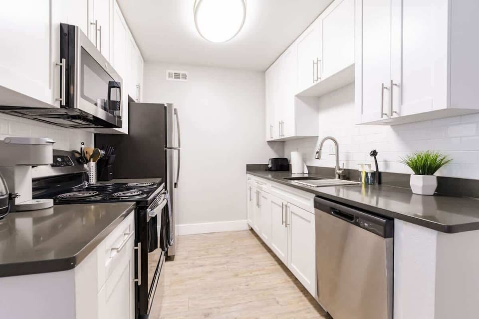 Modern galley-style kitchen with full-size stainless steel appliances, elegant finishes and everything you need for home-cooked meals