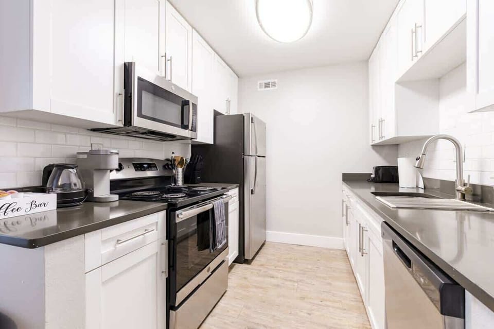 A sleek kitchen with stainless steel appliances and pristine white cabinetry