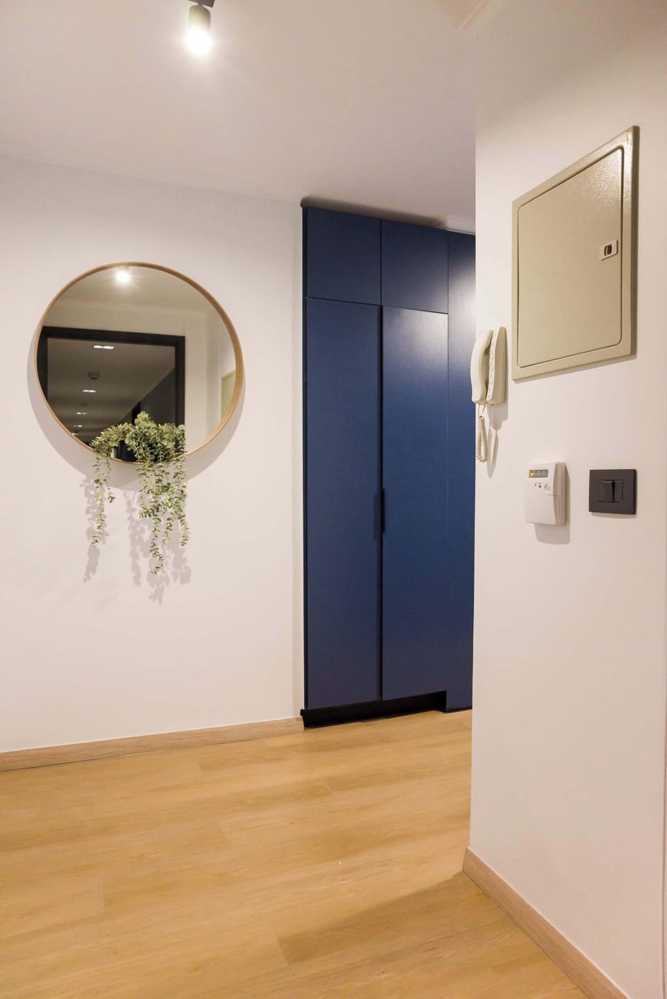 Welcome to your chic retreat with a modern blue wardrobe and elegant mirror, setting the tone for a stylish stay.