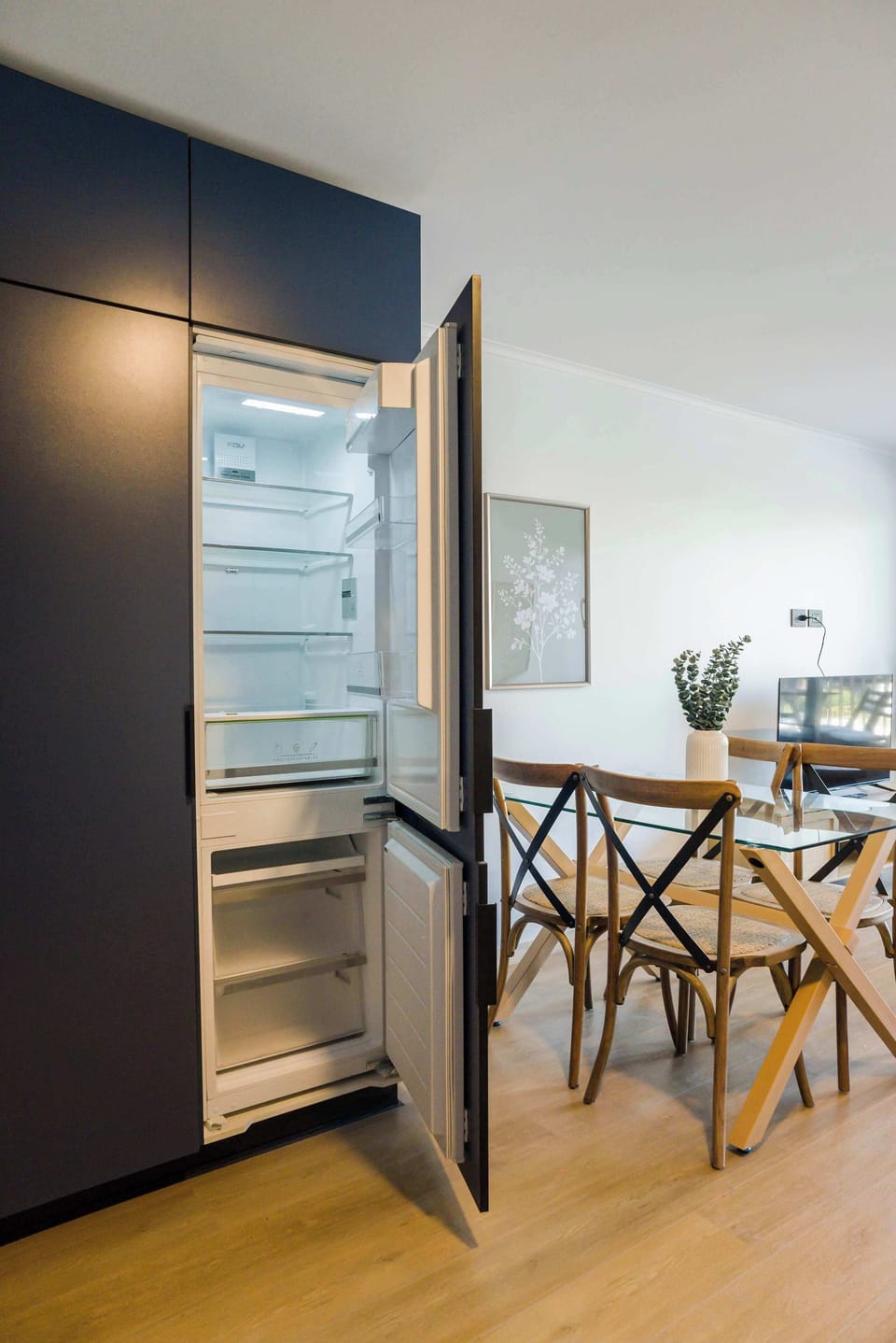 Sleek kitchen with a modern fridge and stylish dining area, perfect for intimate meals.