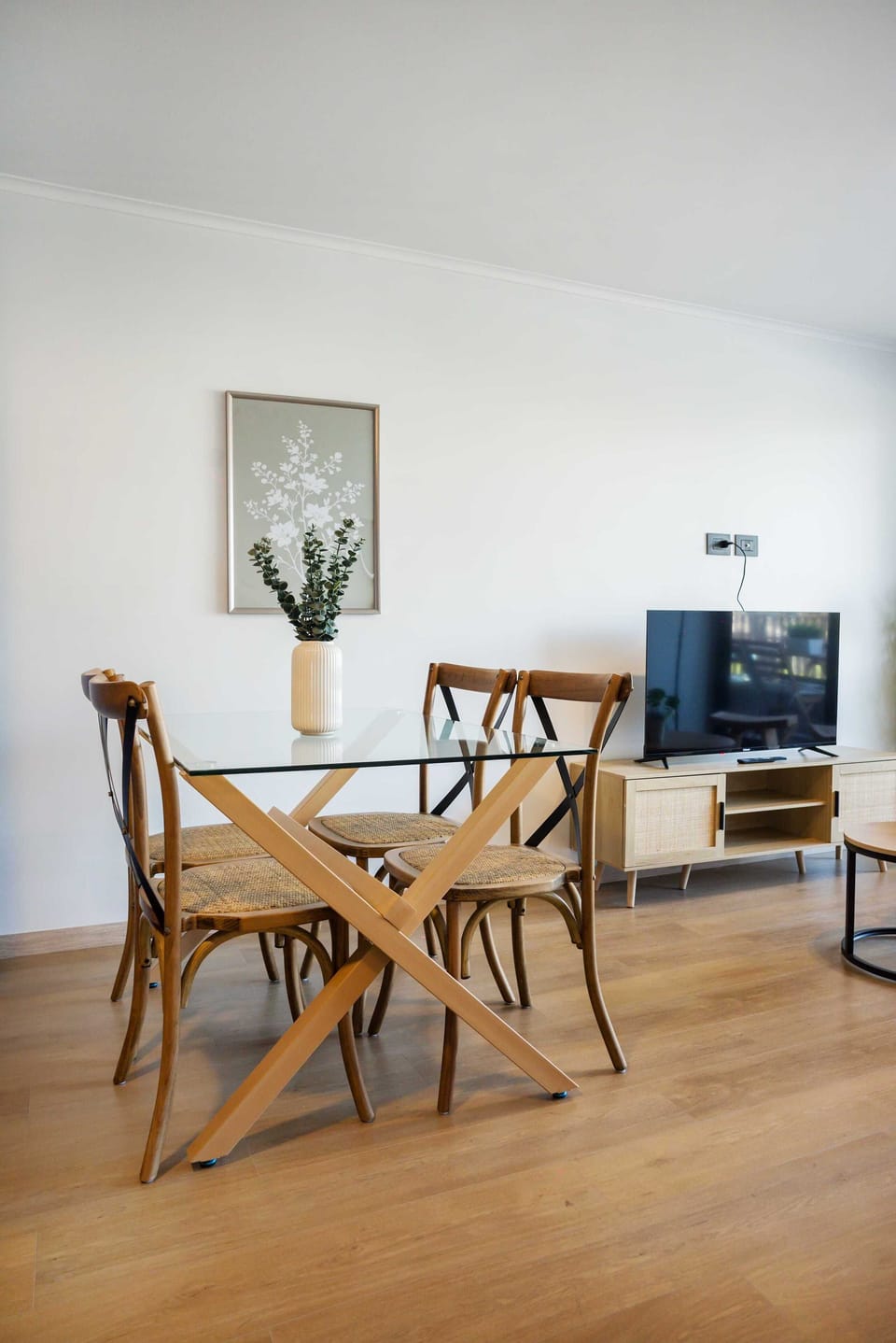 Modern dining area with a sleek glass table and cozy seating, perfect for intimate gatherings.