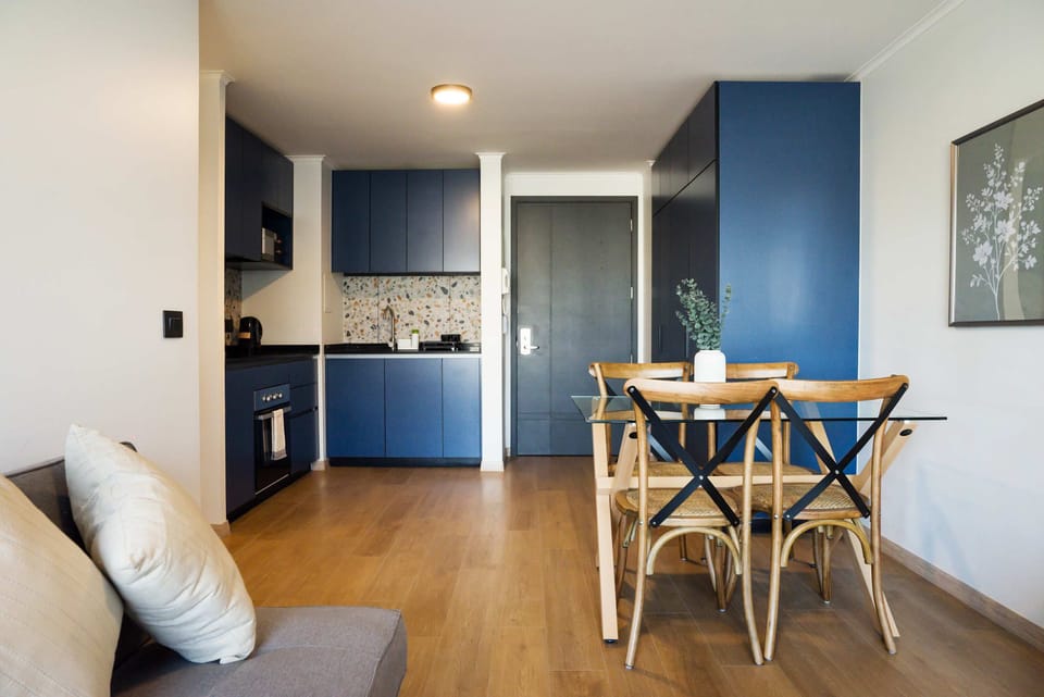 Enjoy cooking in this stylish kitchen with sleek blue cabinets and a cozy dining space for memorable meals.