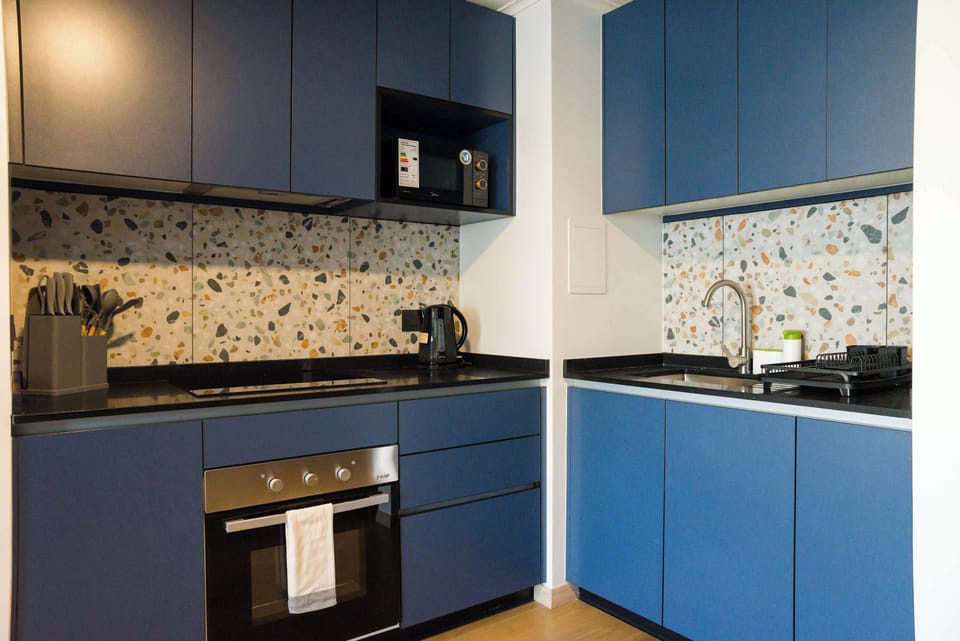 Sleek blue kitchen with terrazzo backsplash, perfect for stylish cooking experiences.