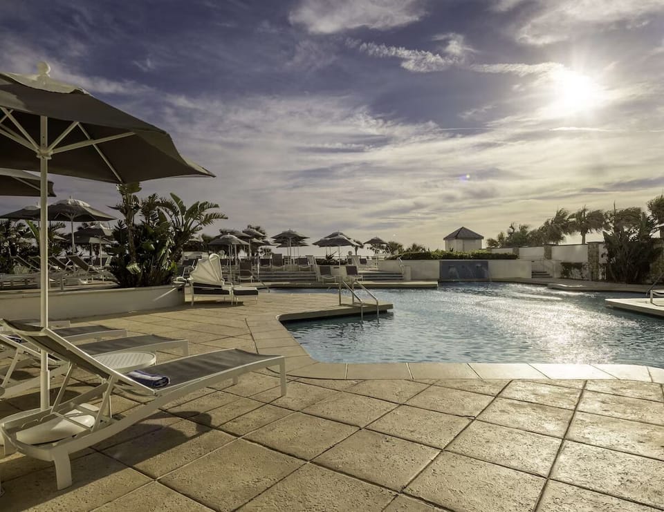 Soak up sunset calm beside the sparkling resort pool.