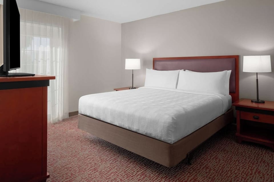 Unwind in a bright bedroom with crisp linens and calm lighting.