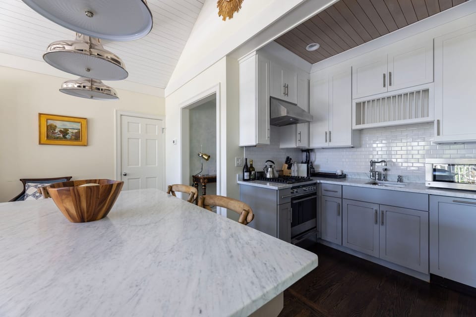 “Gather around the marble island in this airy, coastal kitchen.”