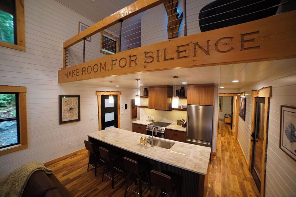 Gather in the heart of the cabin — a chef’s kitchen with high-end appliances, a spacious island, and the inspiring “Make Room for Silence” beam above.