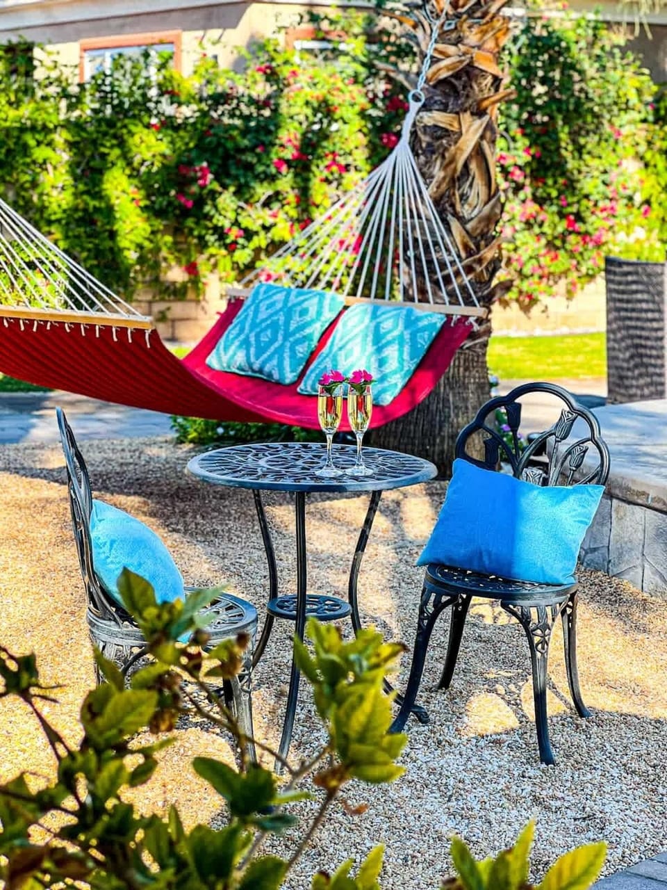 Garden Retreat: Charming bistro seating and a hammock tucked among lush greenery—perfect for a quiet morning coffee or afternoon break.