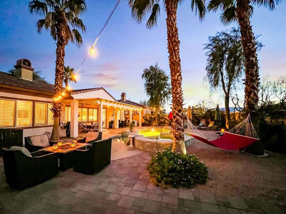 Backyard Oasis: Spacious private backyard with pool, spa, multiple lounge areas, hammocks, and beautiful evening ambiance.