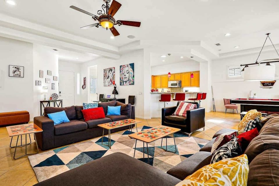 Open-Concept Living Room: Spacious gathering area with multiple seating zones, colorful accents, and an easy flow into the kitchen and game area.