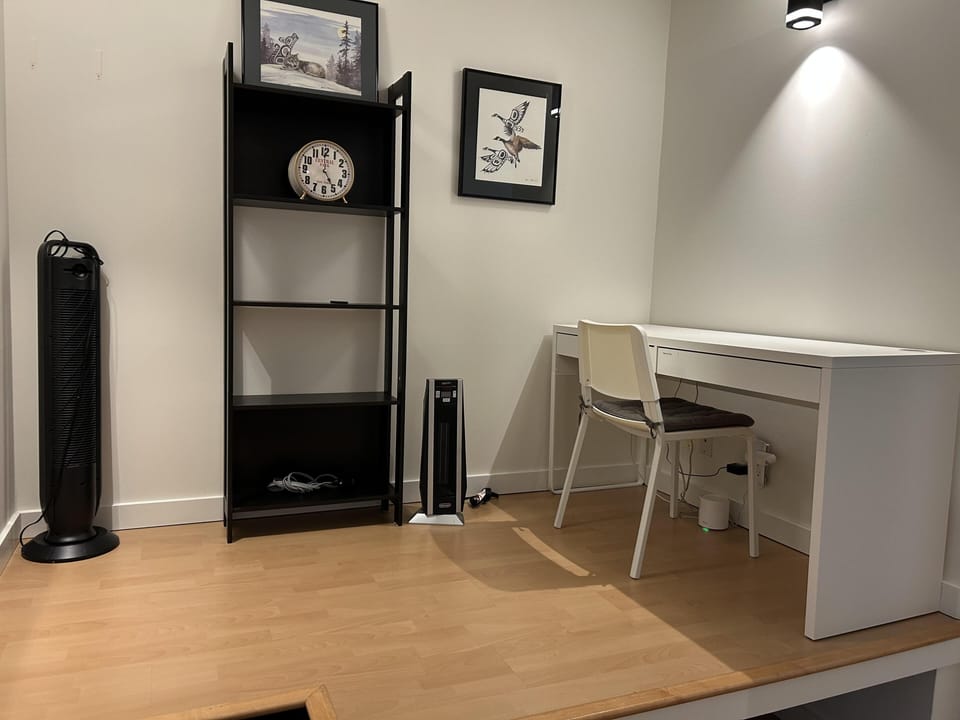 Dedicated home office nook equipped with a desk, chair, and shelving for remote work or study.
