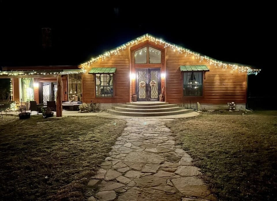 Cozy cabin glow | A warm welcome under the night sky, complete with twinkling lights and rustic charm.
