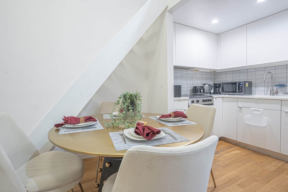 Dining nook for four adjacent to modern kitchen, with stainless appliances and cozy seating.