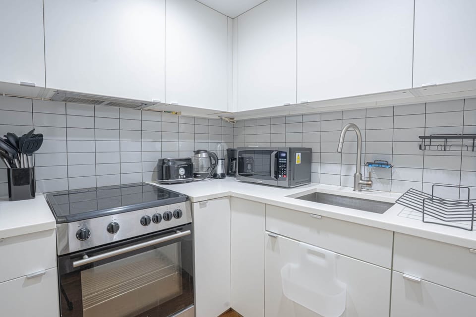 Modern kitchen with full-size stainless appliances, ample counter space and minimalist design.